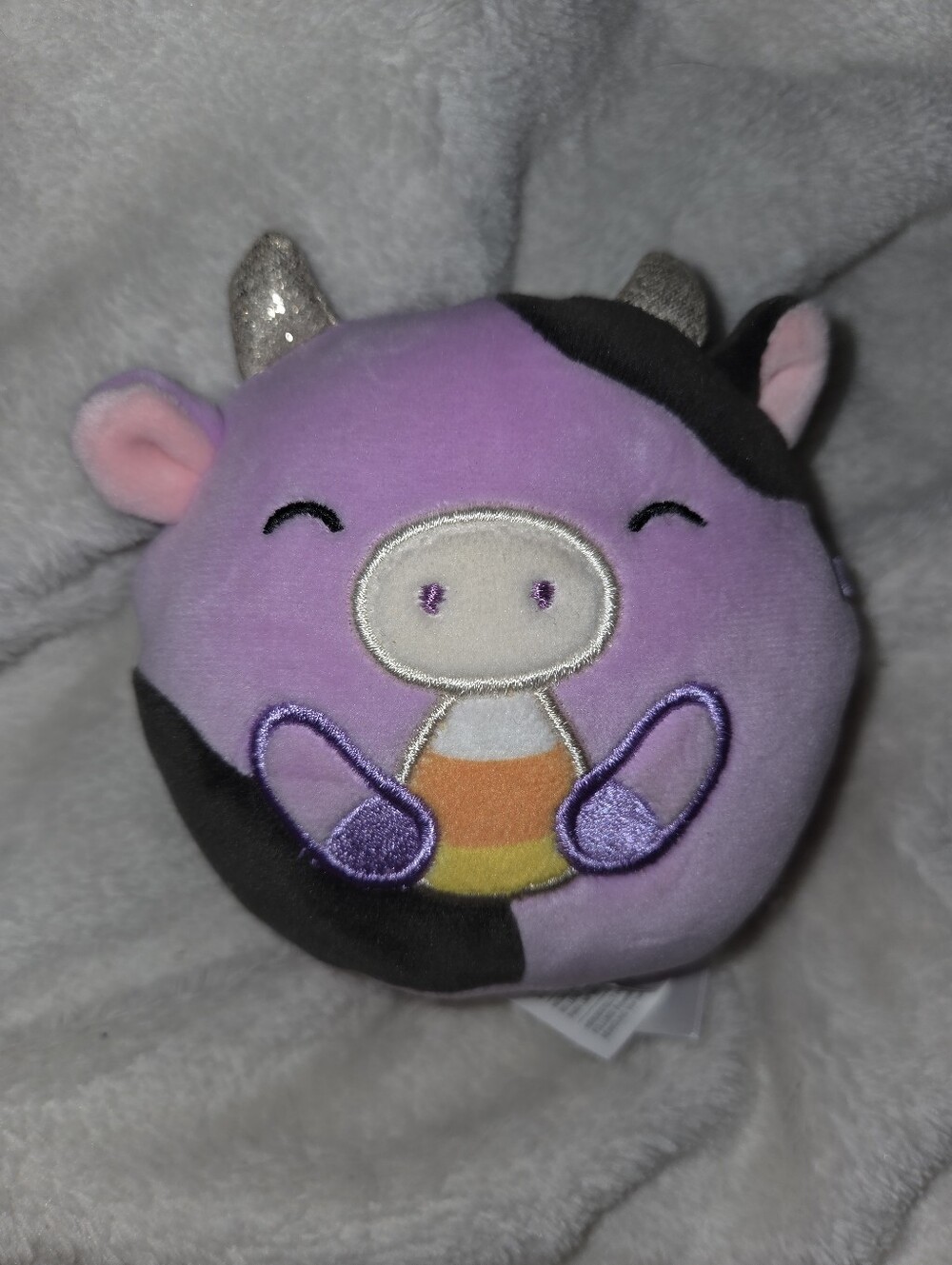 4.5" Squishmallows Halloween Alexie the Purple Cow holding Candy Corn plush